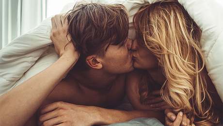 Ein Pärchen liegt im Bett und küsst sich - Foto: istock_franckreporter