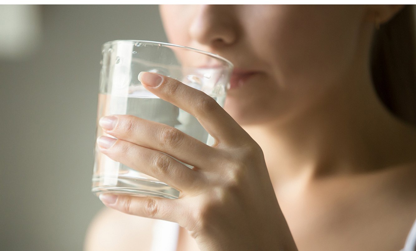 Frau in der 11. SSW trinkt Wasser