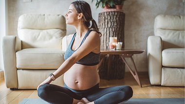 Eine schwangere Frau macht zuhause Yoga - Foto: iStock_svetikd