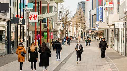 Menschen in einer Fußgängerzone mit Geschäften - Foto: iStock/IMAGO Rupert Oberhäuser