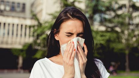 Eine Frau, die an einer Allergie leidet, putzt ihre Nase - Foto: iStock/blackCAT