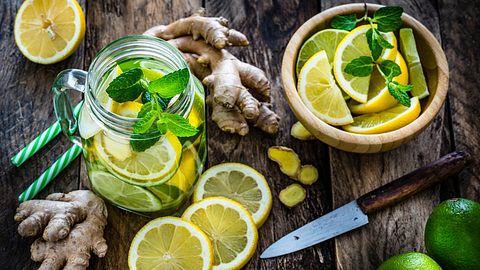 Zitronen-Ingwer-Wasser in einer Karaffe und geschnitene Zitronenscheiben in einer Schale - Foto: istock_fcafotodigital