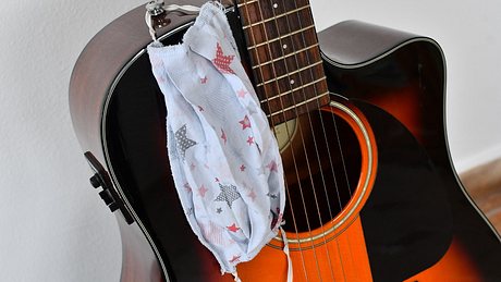 Gitarre und Mundschutz - Foto: Istock/Filip Viranovski