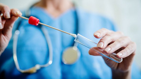 Eine Ärztin steckt ein Wattestäbchen mit einerm Abstrich in eine Plastikhülle - Foto: iStock/dusanpetkovic