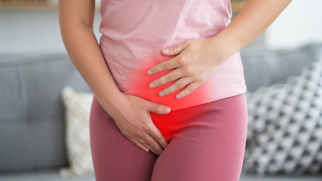 Frau fässt sich an den Bauch und Intimbereich - Foto: iStock/Staras