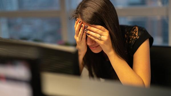 Eine Frau sitzt vorm Computer und hält sich den Kopf - Foto: iStock/FG Trade