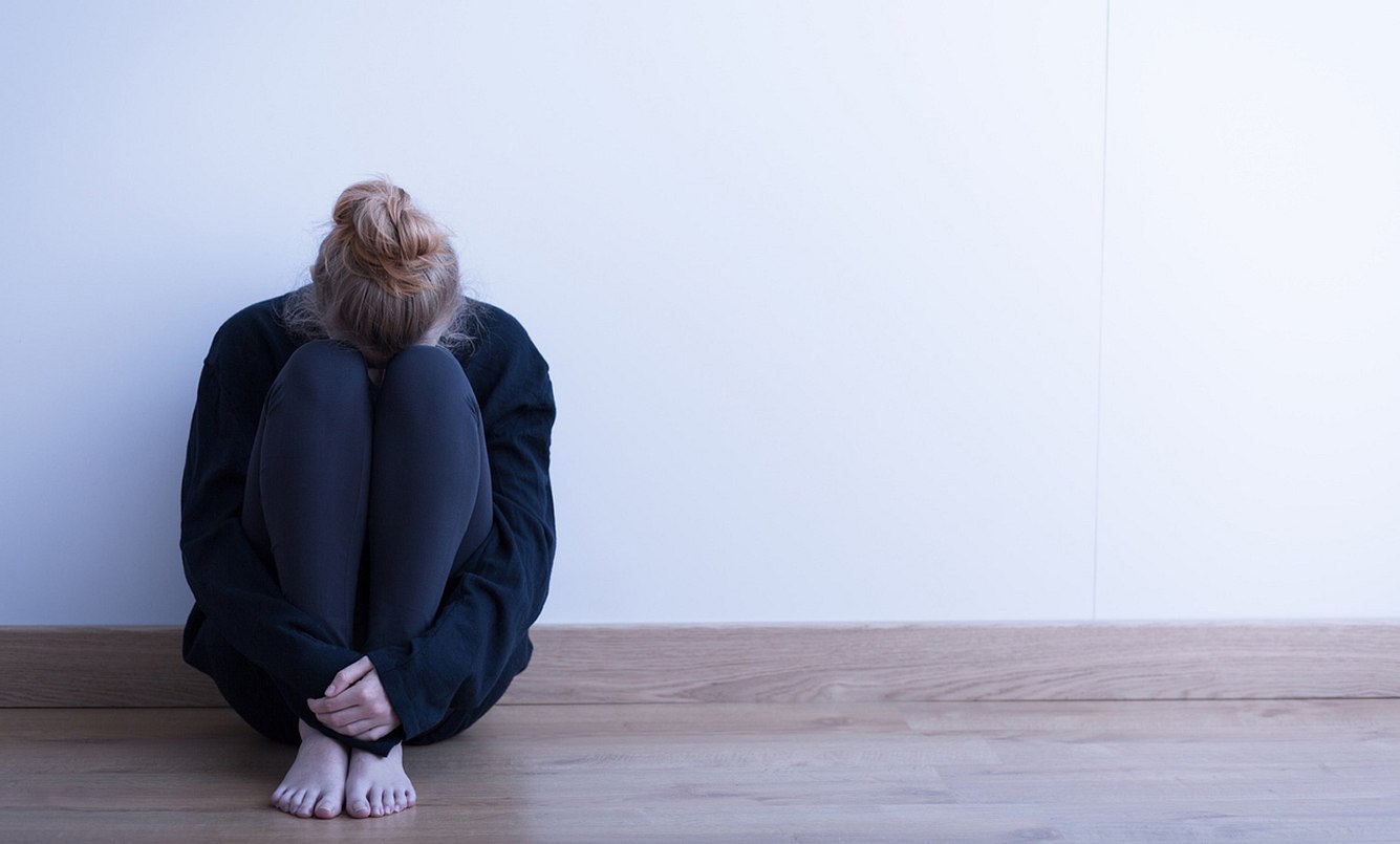 Frau mit Agoraphobie sitzt auf dem Boden