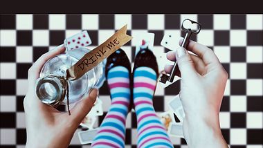 Alice im Wunderland hält Flasche und Schlüssel in den Händen - Foto: iStock/Svetlana_Smirnova