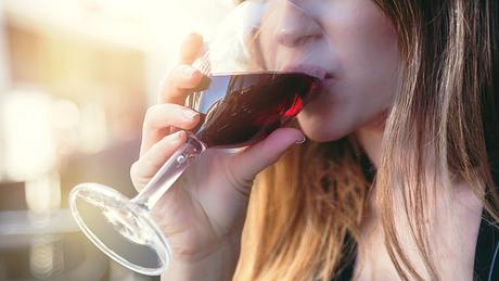 Eine Frau trinkt Rotwein - Foto: iStock/Circle Creative Studio