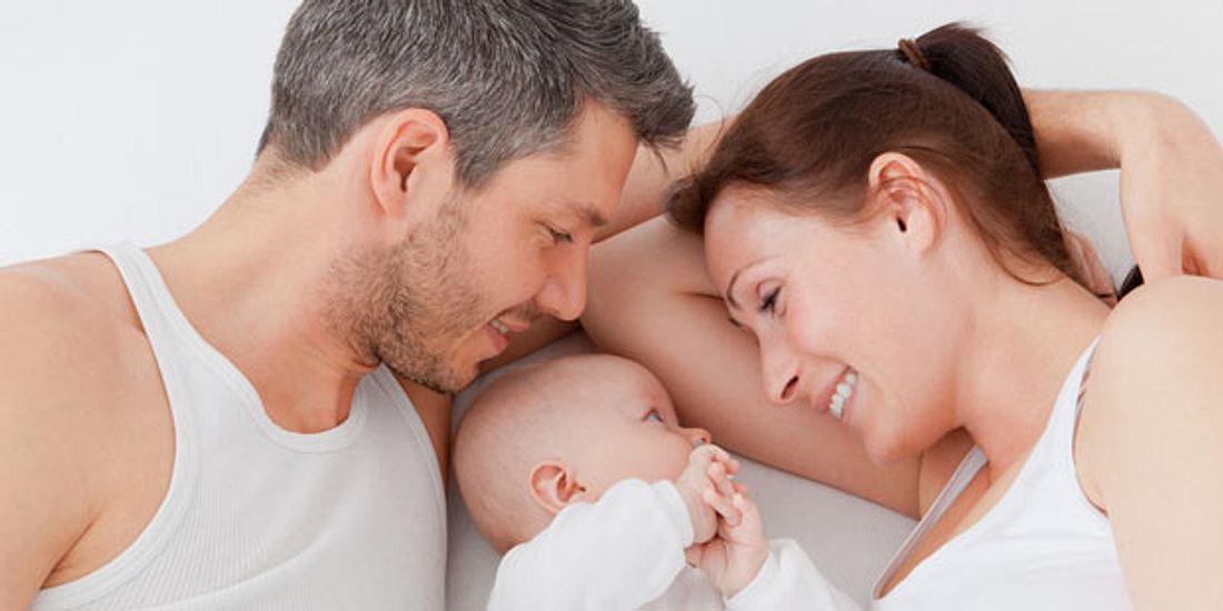 Ob Ihr Baby Allergien entwickeln wird, hängt neben Umwelteinflüssen auch von den Genen ab Paar mit Baby im Bett