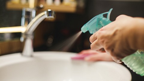 Eine Frau putzt das Waschbecken - Foto: iStock_fotostorm