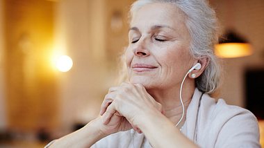 Ältere Frau hört mit Kopfhörern Musik - Foto: iStock/shironosov