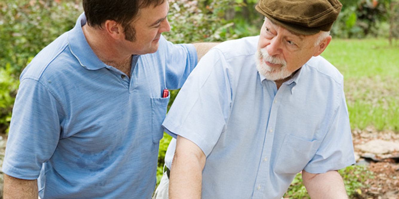 Ein junger Mann spricht mit einem alten Mann im Garten
