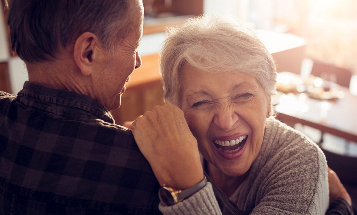 Ältere Frau und Mann lachen zusammen