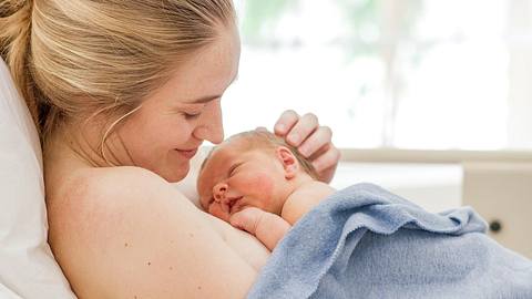 Mutter bei einer ambulanten Geburt mit ihrem neugeborenen Baby auf der Brust - Foto: istock/fatcamera