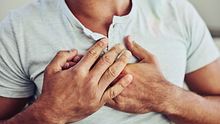 Ein Mann hält sich die Brust. - Foto: iStock / PeopleImages