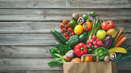 Eine Papiertüte voll mit verschiedenen Gemüse- und Obstsorten - Foto: istock_AlexRaths