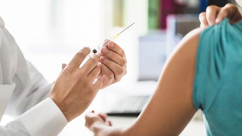 Ein Apotheker impft einen Kunden - Foto: Tero Vesalainen/iStock