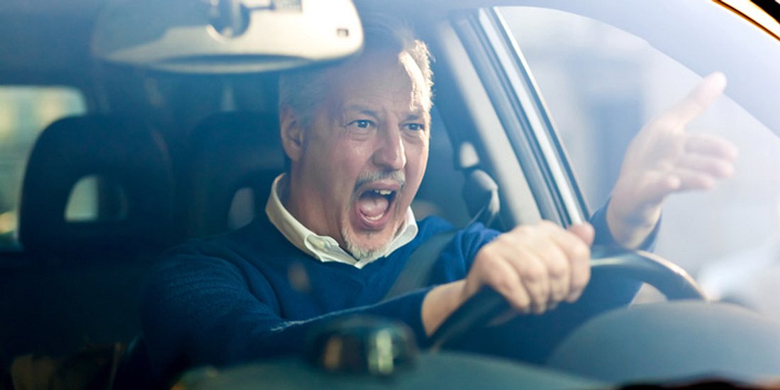 Ein Autofahrer steht im Stau, sein Ärger ist groß