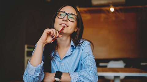 Eine Frau schaut verträumt in die Luft - Foto: iStock/audiLab