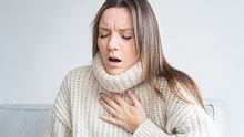 Eine Frau hat hält sich die Brust und hat Probleme beim Atmen.  - Foto: iStock/Daria Kulkova