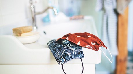 Selbst genähte Atemschutzmasken liegen auf einem Waschbecken - Foto: istock/rike_