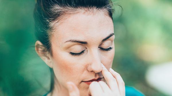 Frau führt eine Atemübung gegen Stress durch - Foto: iStock/microgen