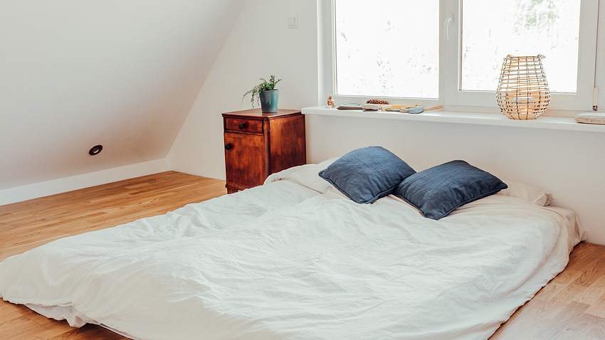 Doppelbett ohne Bettgestell auf einem Holzfußboden - Foto: iStock/Helin Loik-Tomson