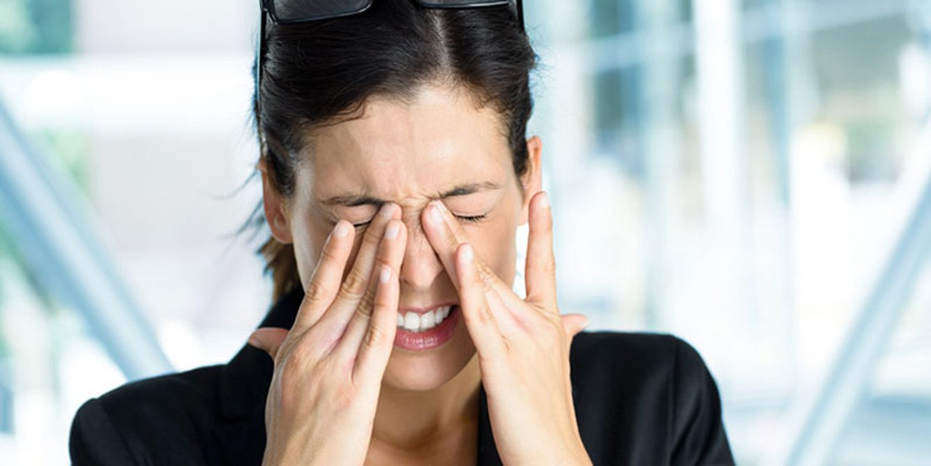 Eine Frau mit Augenschmerzen