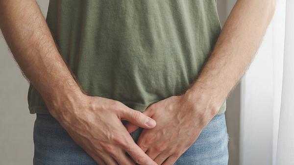Ein Mann hält sich seine Hände vor den Penis - Foto: iStock/Vladdeep