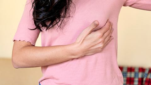 Eine Frau fasst sich unter die Brust - Foto: iStock/RealPeopleGroup