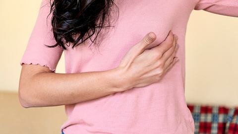 Frau fässt sich unter die Brust - Foto: iStock/RealPeopleGroup