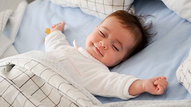 Baby lächelt im Schlaf - Foto: iStock/javi_indy