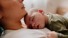 Ein Baby liegt schlafend auf der Brust einer Frau. - Foto: iStock / Studio4 