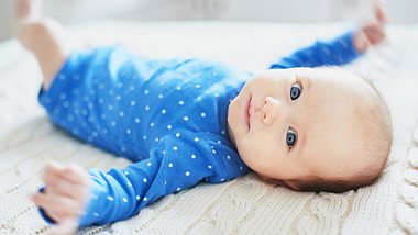 Ein Baby liegt auf dem Rücken und blickt in die Kamera - Foto: istock_encrier