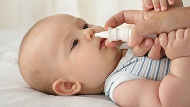 Eine Mutter verwendet bei ihrem Baby Nasenspray - Foto: iStock_markokg