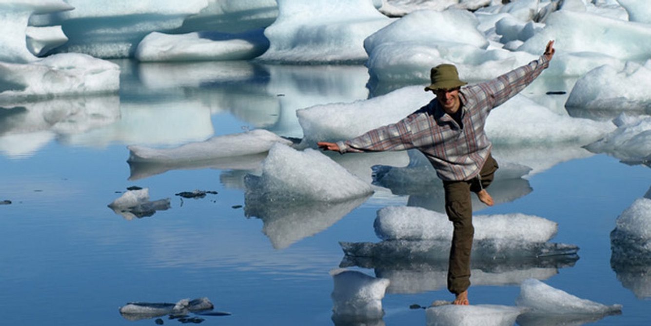 Ein Mann hüpft barfuß über Eisschollen