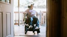 Eine Person ist im Rollstuhl und dabei ein Haus zu betreten.  - Foto: iStock/RyanJLane