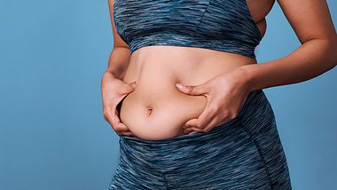 Eine Frau hält mit beiden Händen ihren Bauch - Foto: istock_katleho Seisa