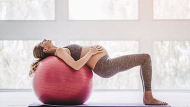 Schwangere rücklings auf Gymnastikball - Foto: iStock/vasyldolmatov