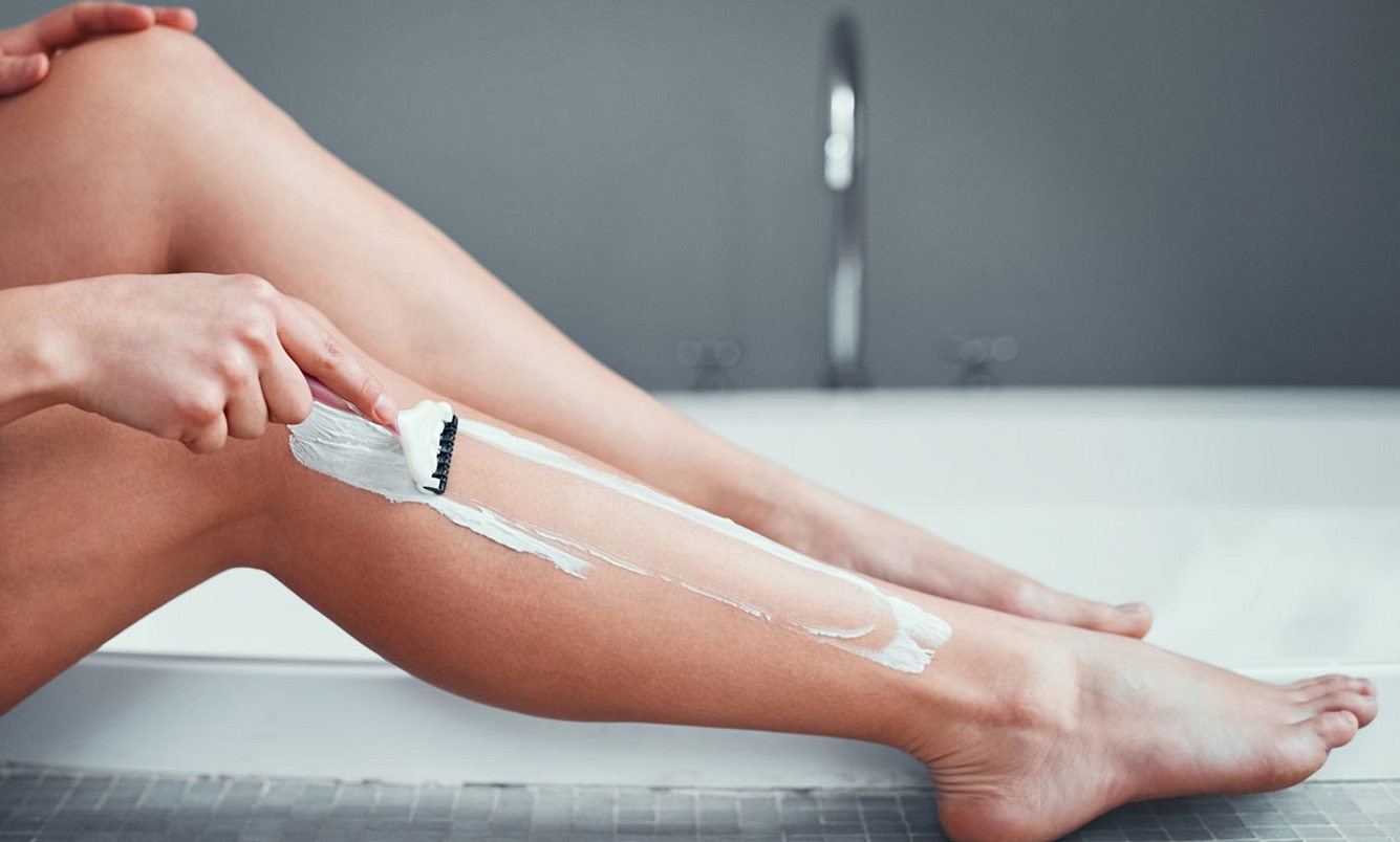 Eine Frau rasiert sich die Beine