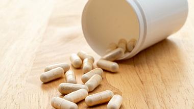 Tabletten und eine Dose auf einem Holzuntergrund - Foto: iStock/clubfoto