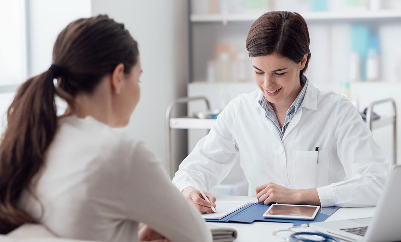 ÄArztin berät ihre Patientin in der Praxis