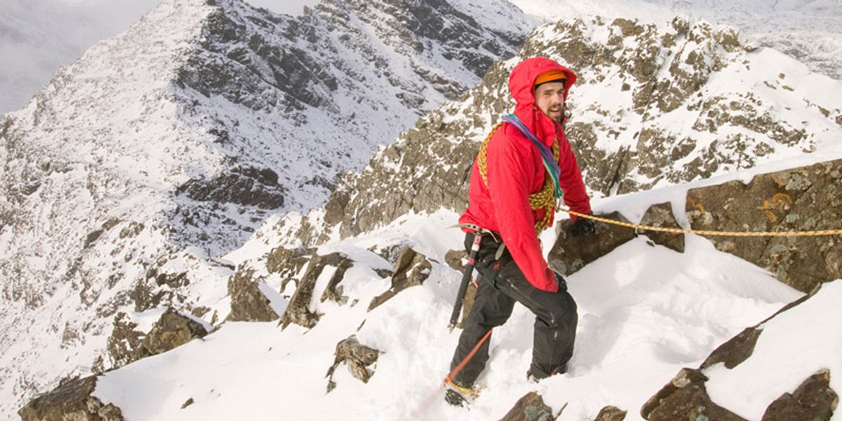 Ein Bergsteiger besteigt einen Berg im Schnee