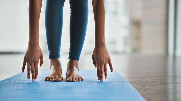 Eine Frau dehnt sich, um ihre Beweglichkeit zu verbessern - Foto: iStock/Delmaine Donson