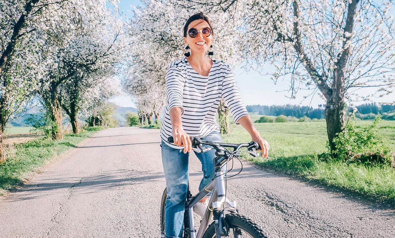 Frau mit Sonnenbrille sitzt auf dem Fahrrad