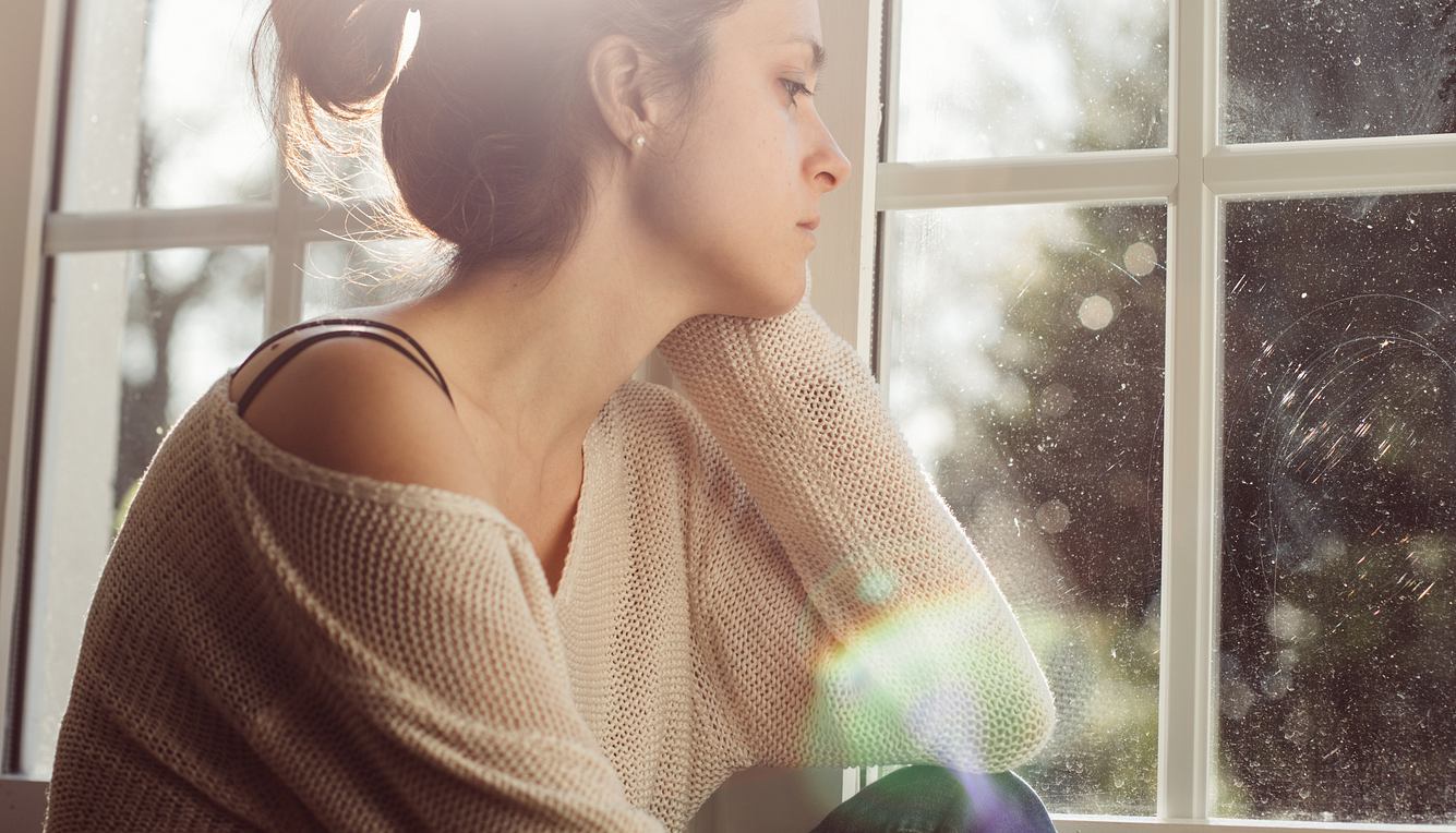 Eine Frau schaut traurig aus dem Fenster