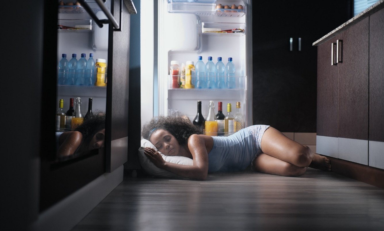 Frau schläft im Kühlschrank