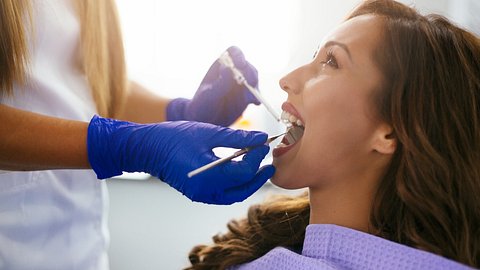 Frau mit offenem Mund beim Zahnarzt - Foto: istock/ciricvelibor