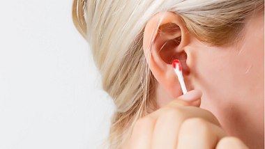 Eine Frau zieht aus ihrem Ohr ein Wattestäbchen, auf dem sich Blut befindet - Foto: iStock_Sinenkiy